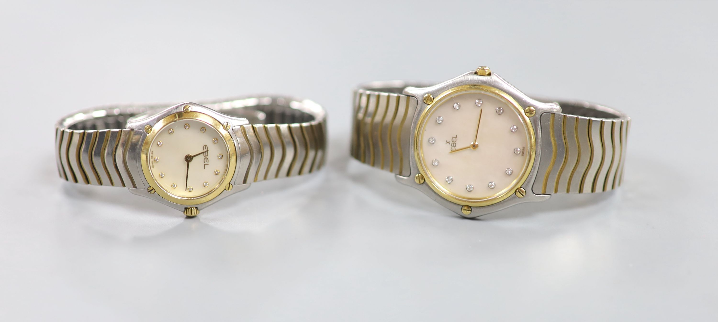 A lady's and gentleman's stainless steel and gold plated Ebel quartz wrist watches, with mother of pearl dials and diamond dot markers, case diameters 32mm and 23mm, no boxes.